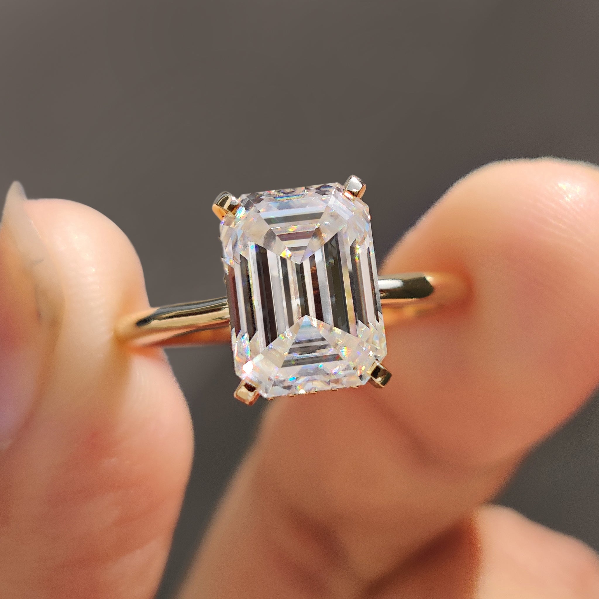 Emerald cut ring crafted in yellow gold with a round cut hidden halo.