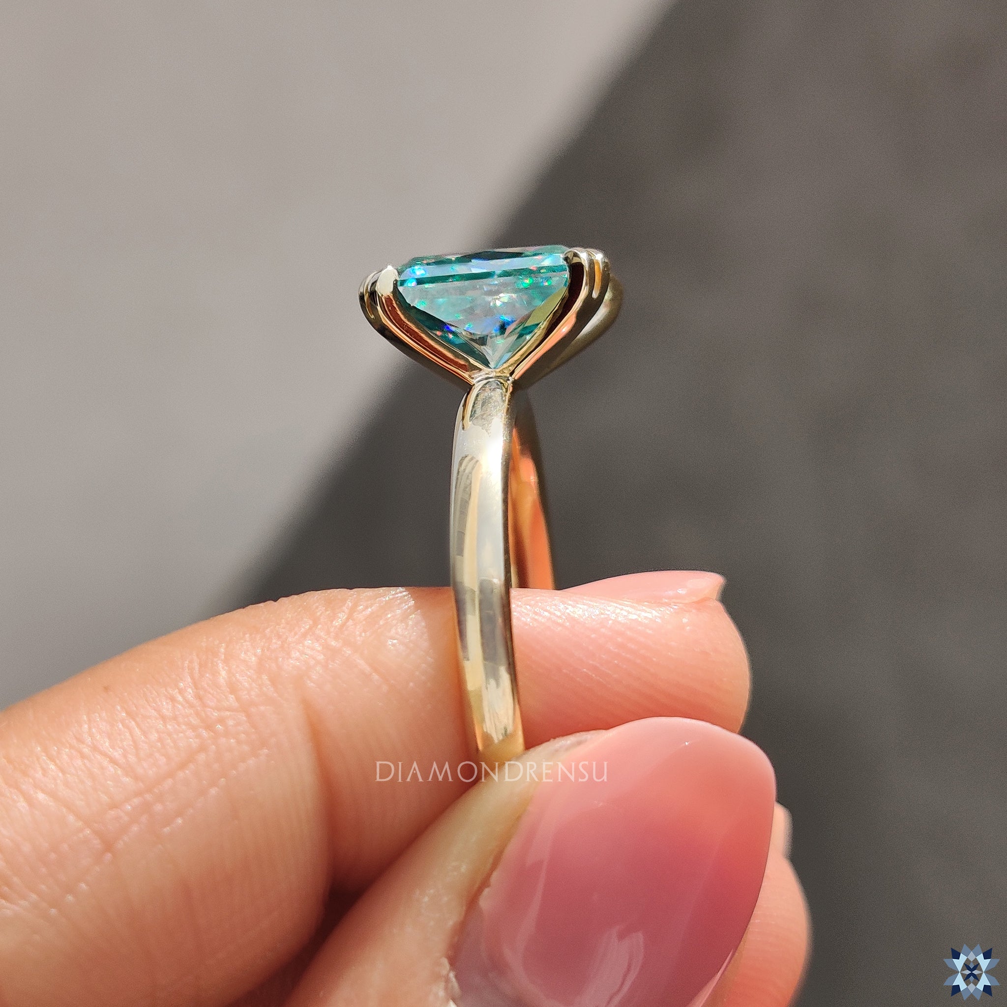 Double tab prong setting enhances radiant cut moissanite brilliance.