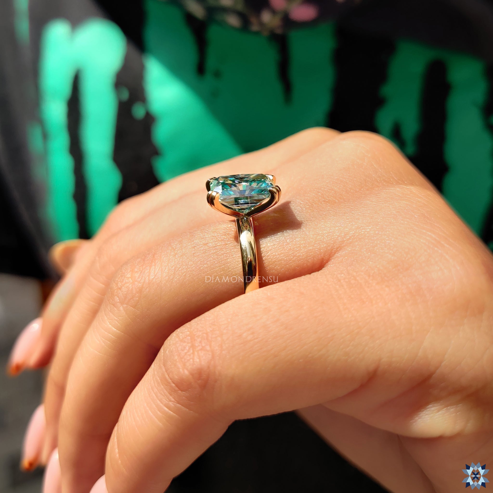 Pave band with round cuts enhances blue princess moissanite centre.