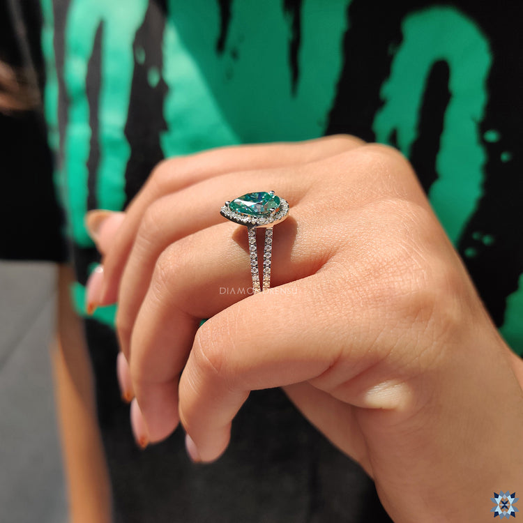 Yellow gold engagement ring with cyan blue pear cut gemstone.