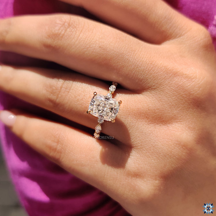 Round cut halo moissanite engagement ring with cushion cut center in yellow gold.