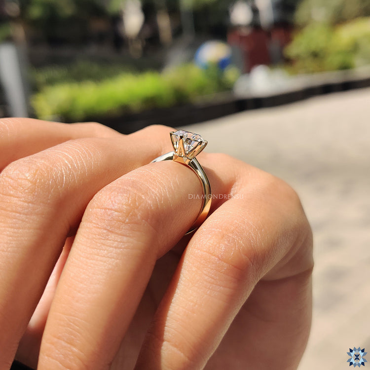 Elegant solitaire ring with round cut moissanite and 6 claw setting in yellow gold.