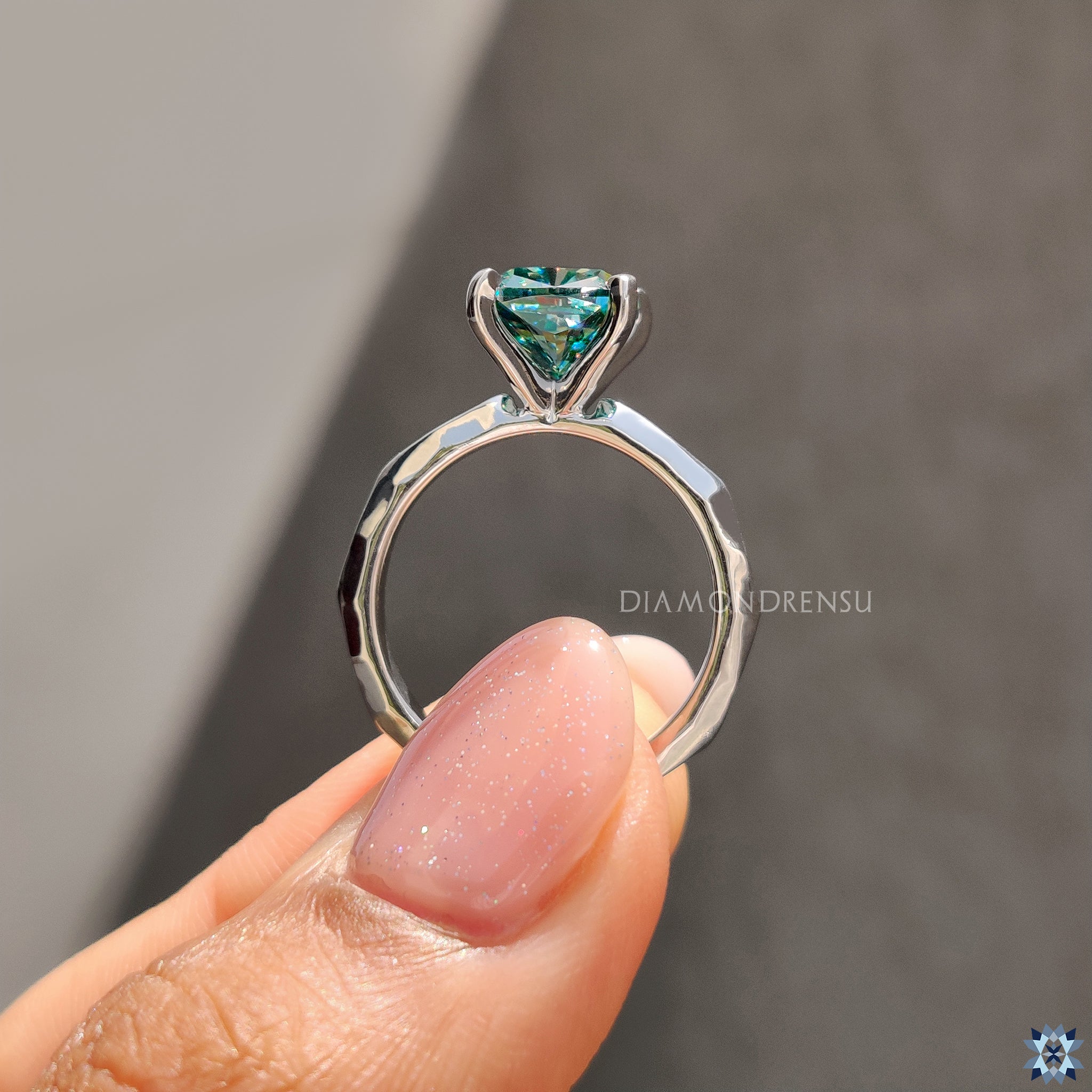 UK engagement ring with cushion cut cyan moissanite and modern solitaire setting.