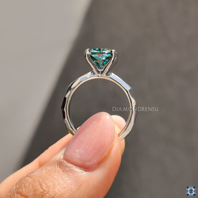 UK engagement ring with cushion cut cyan moissanite and modern solitaire setting.