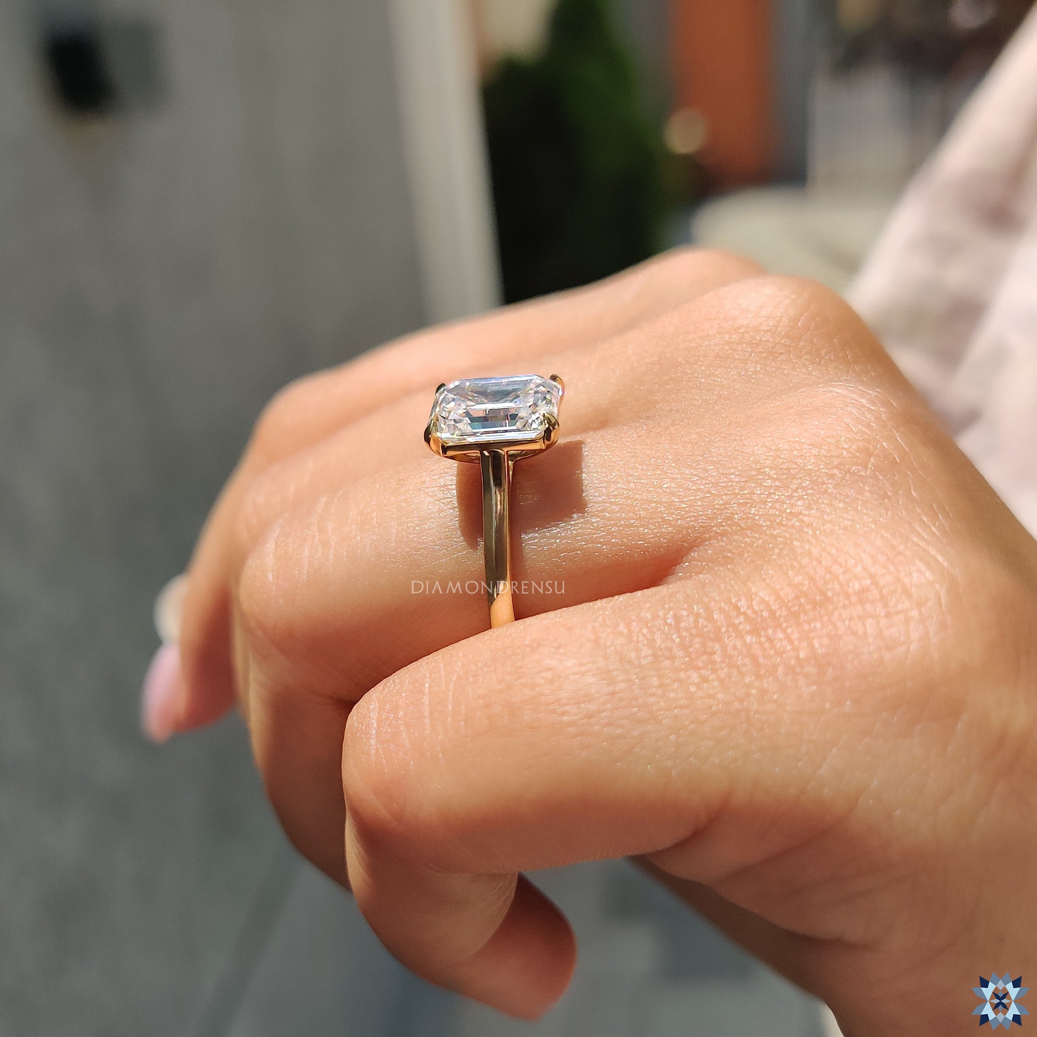 Minimalist moissanite engagement ring in yellow gold featuring elegant emerald cut.