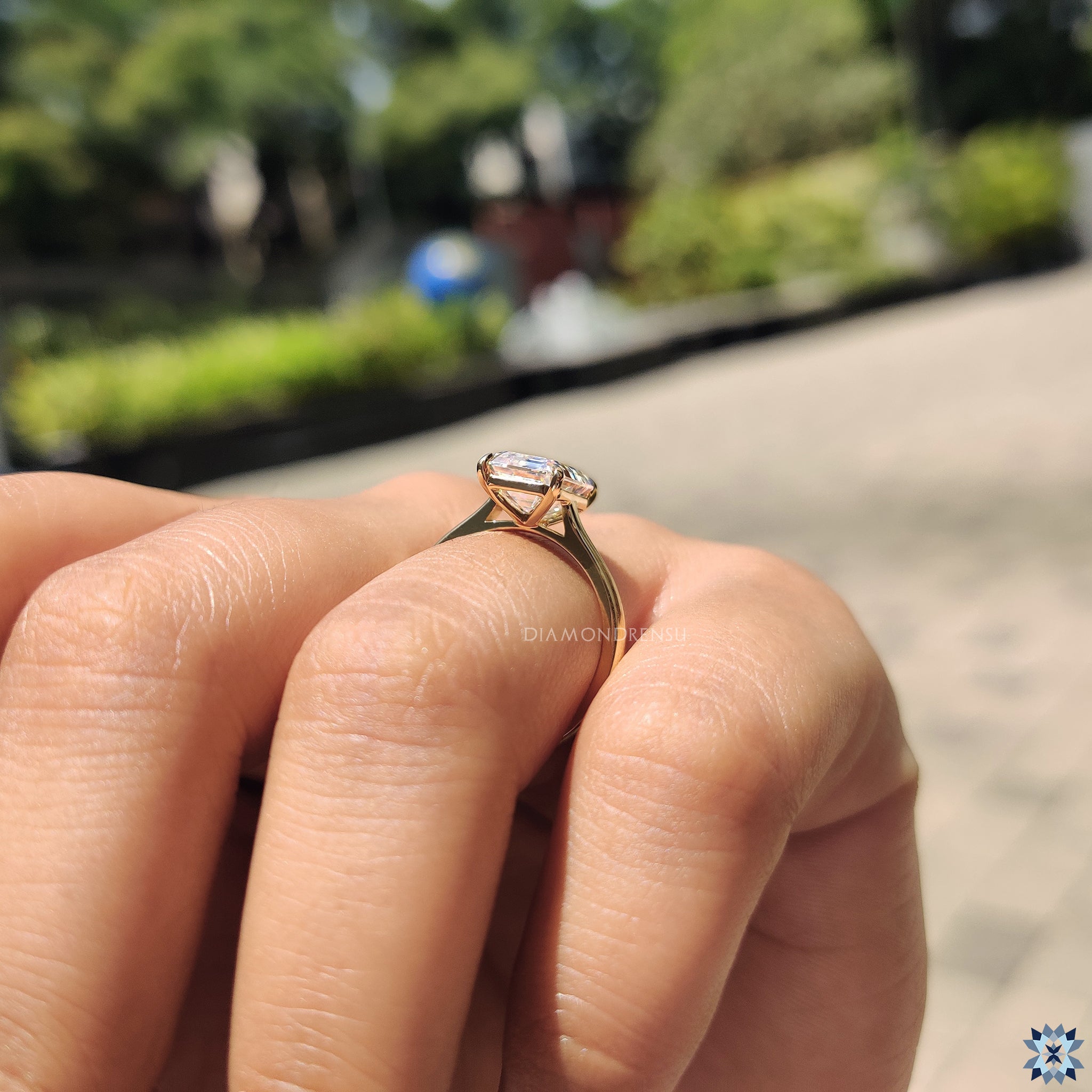 UK engagement ring with emerald cut moissanite in a classic 4 prong solitaire setting.