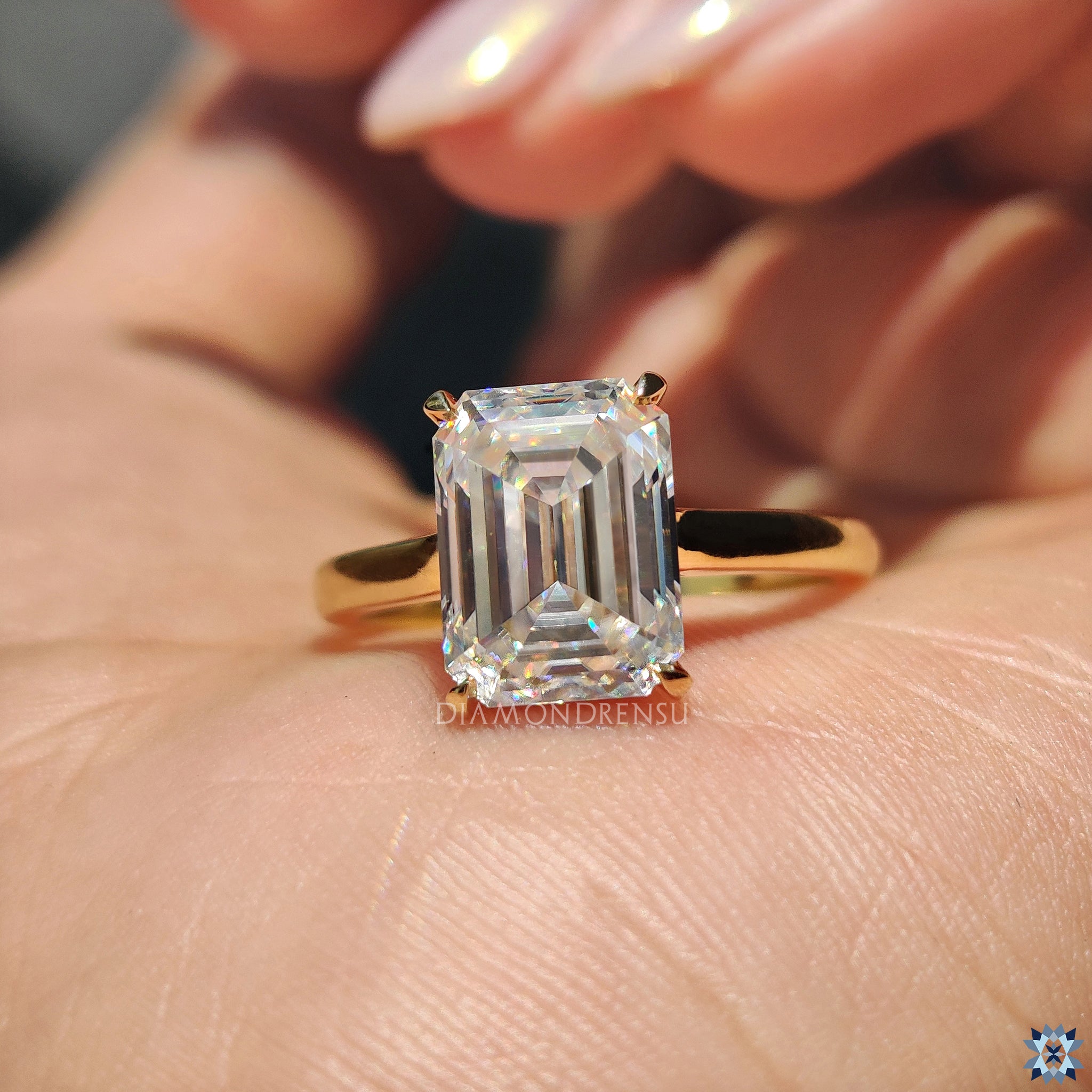 Handmade emerald cut moissanite ring in cathedral setting with elegant gold band.