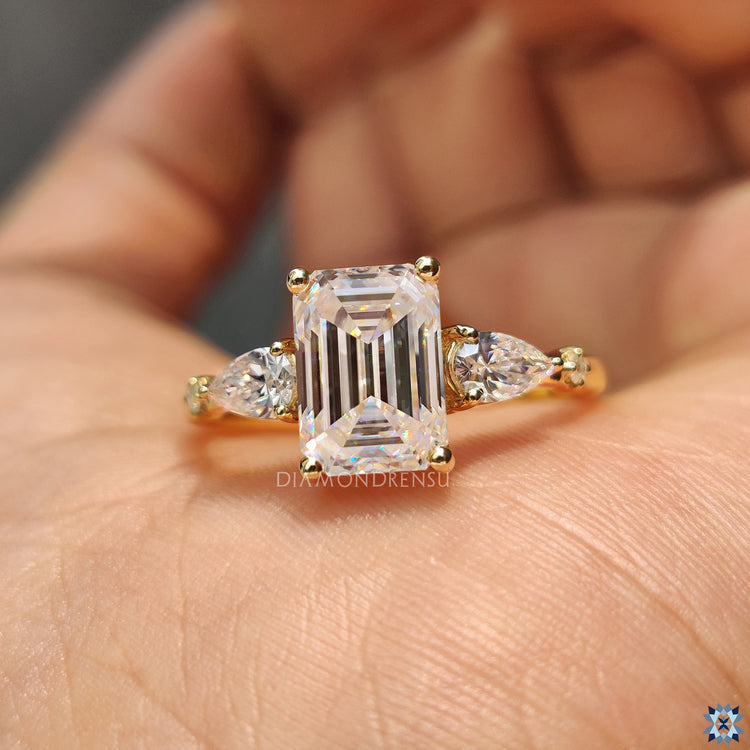 UK engagement ring with emerald moissanite and two pear side stones.