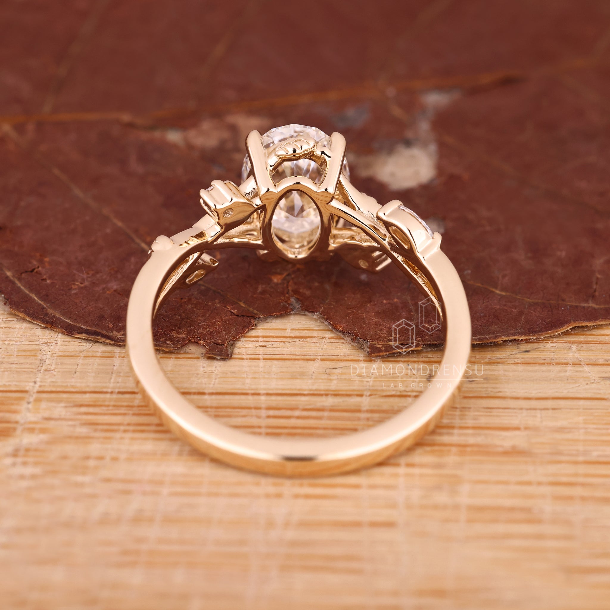 Gold engagement ring with oval diamond and nature-inspired design