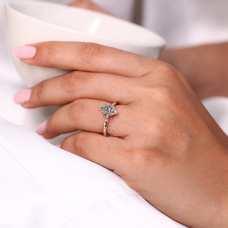 Six claw prong setting holds the marquise diamond.