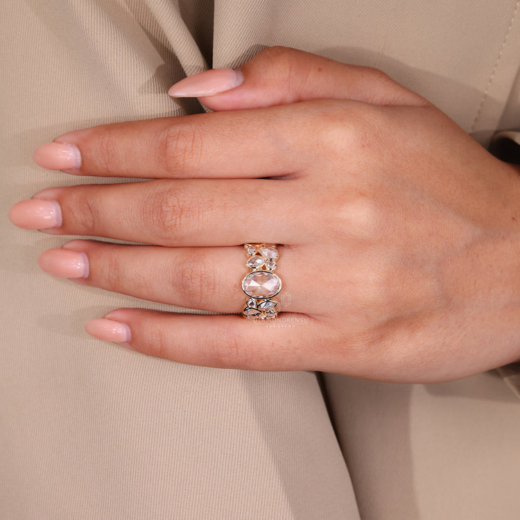 Bezel engagement ring design holds oval rose cut center stone.