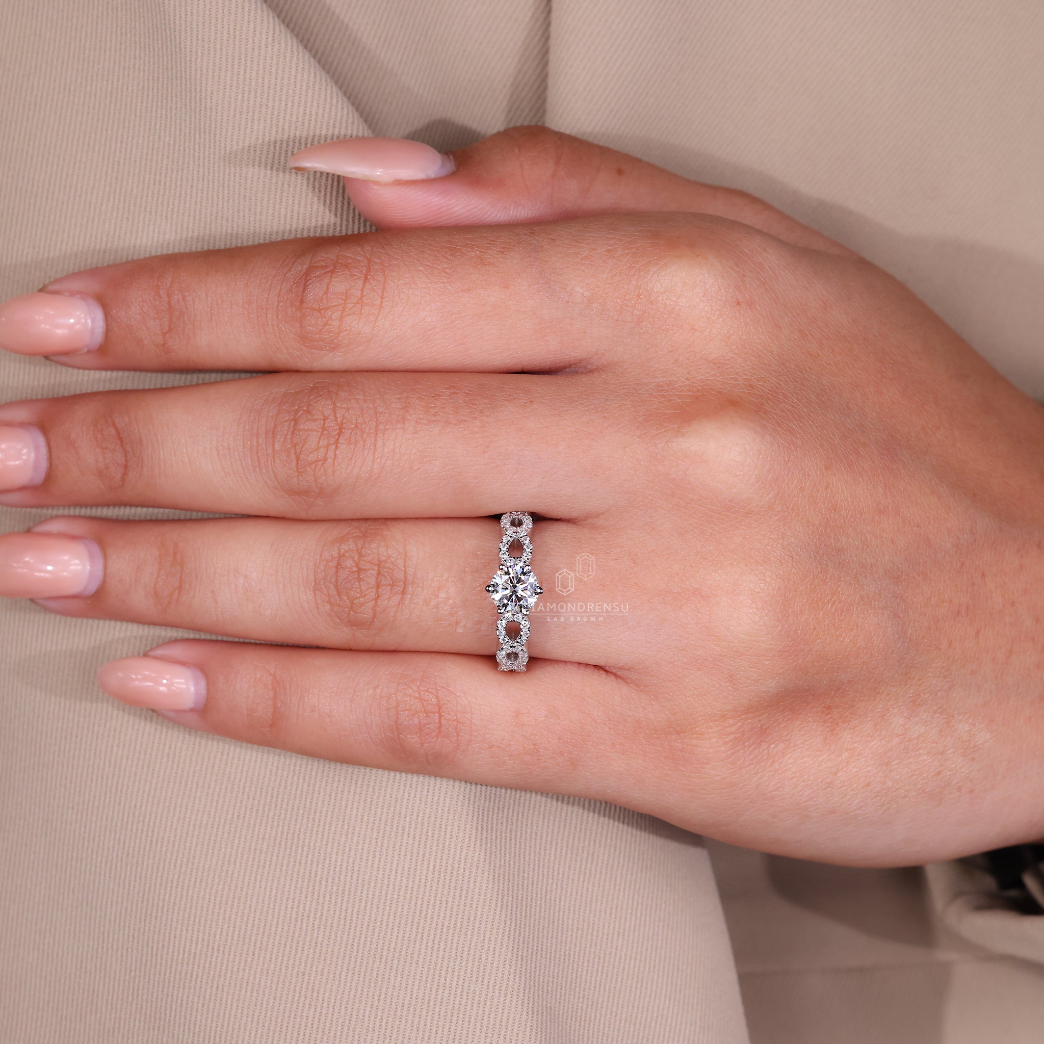 Round diamond ring with twisted pave band, set in white gold.