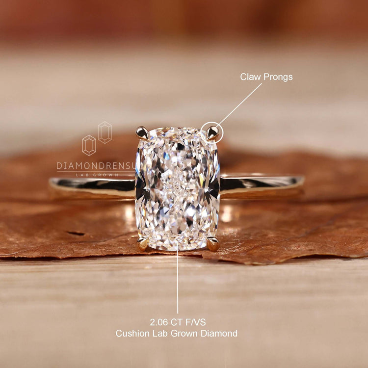 Classic solitaire engagement ring with a cushion cut diamond and claw prongs.
