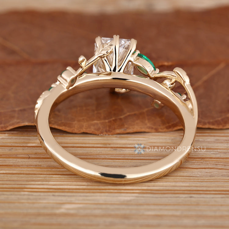 Green emerald gemstone ring with radiant cut diamond.