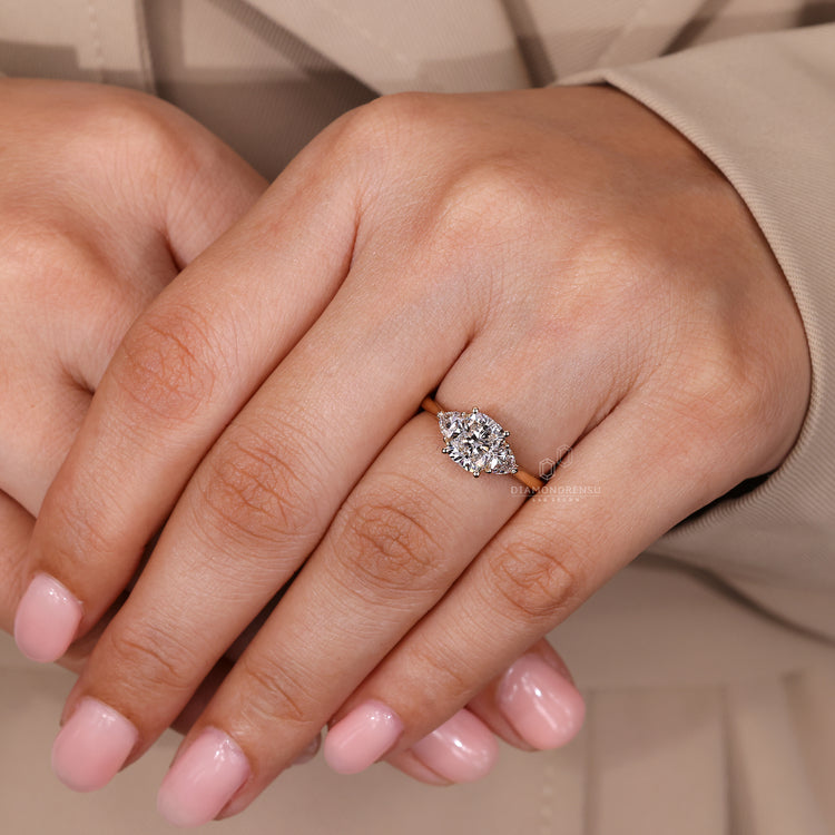 Cushion diamond ring with three stone and cathedral setting.