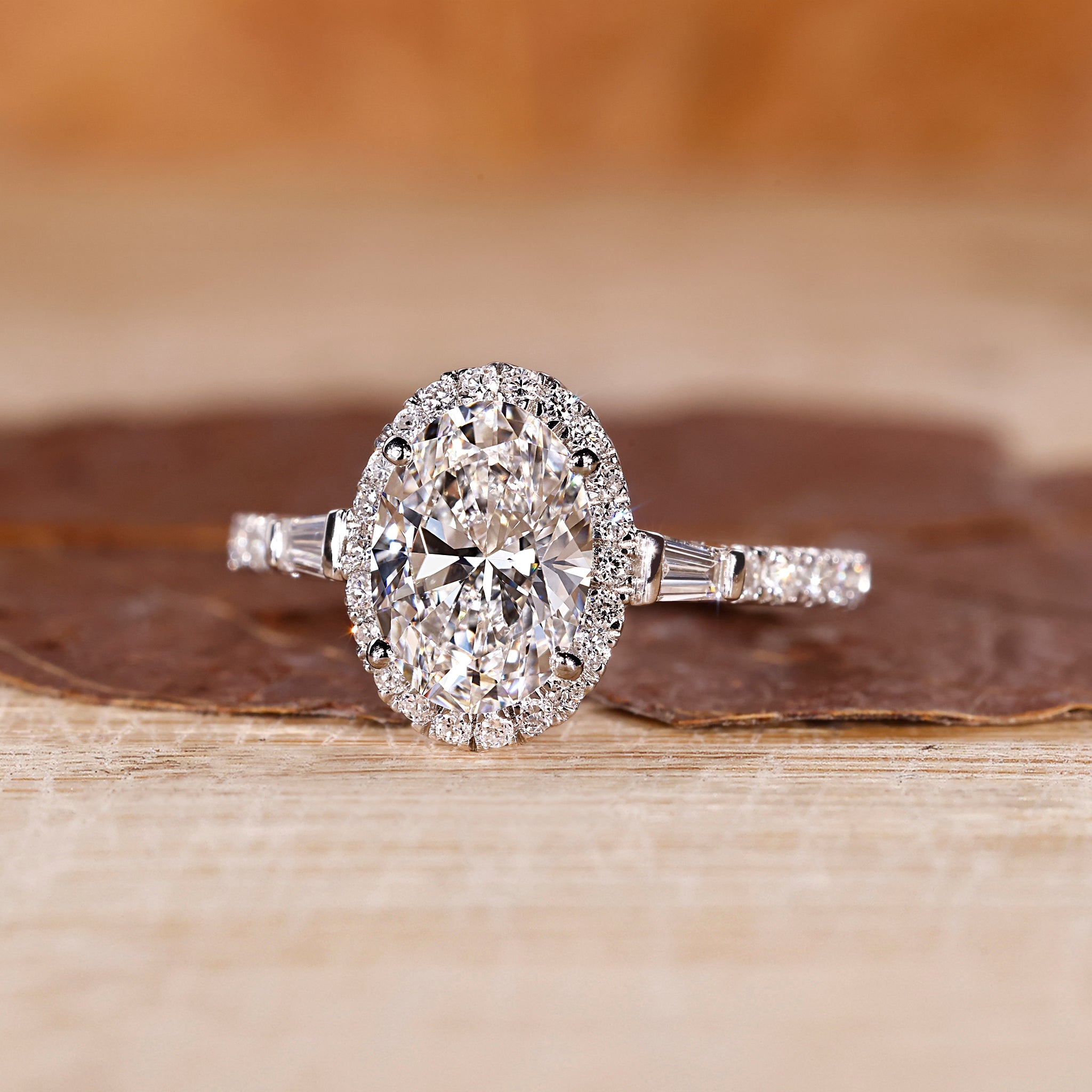 Oval gold diamond engagement ring with tapered baguette diamonds