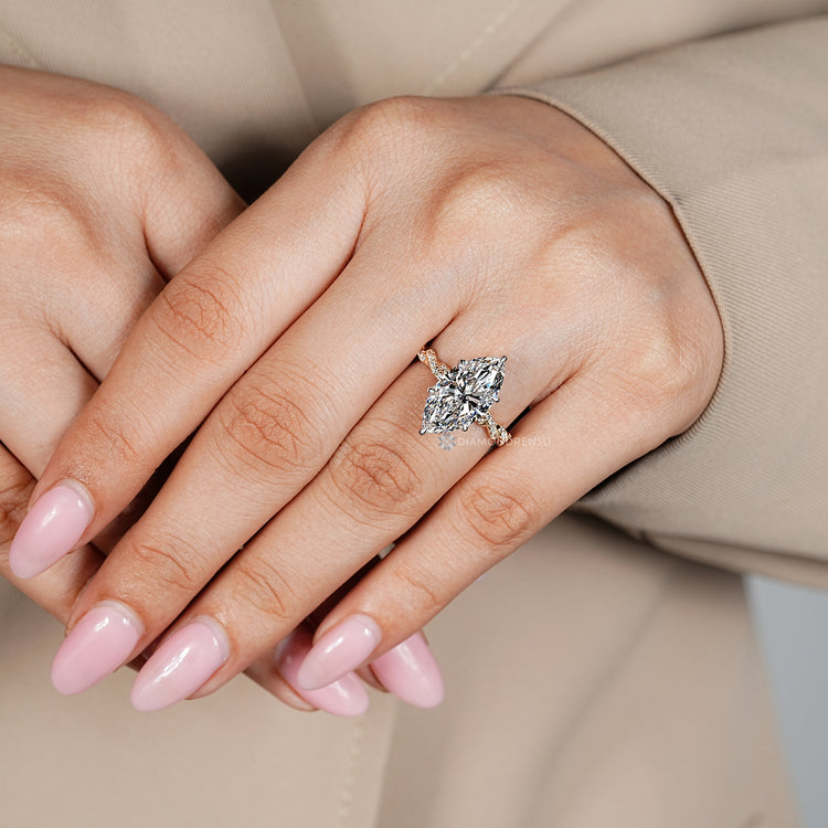 Marquise diamond ring with round diamond pavé style.