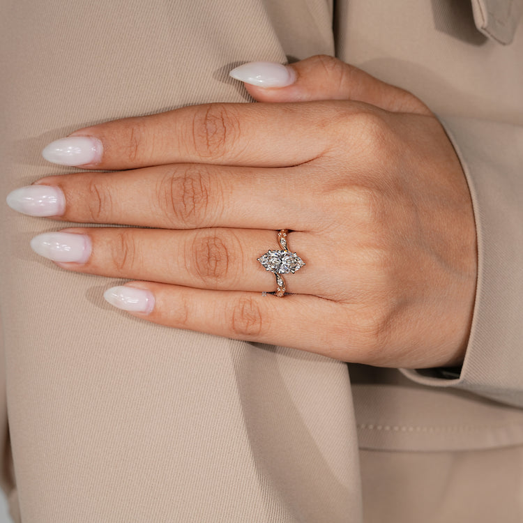 Marquise and round diamond ring with six claw prongs.