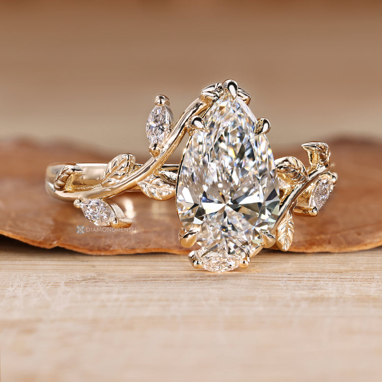 Pear diamond ring with marquise side stone accents.