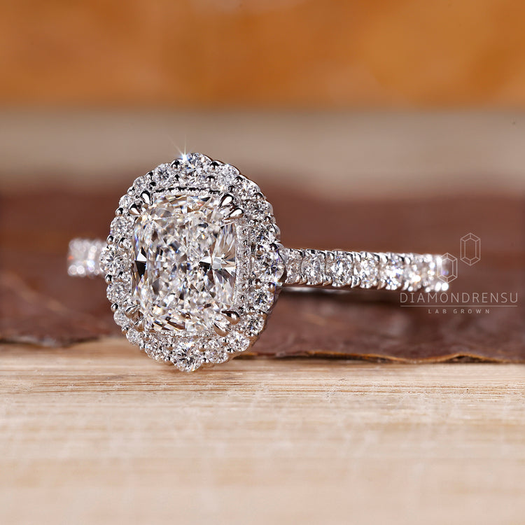 Handmade cushion diamond ring with halo and milgrain edges.