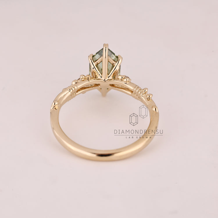 Nature inspired green diamond ring with round side stones.