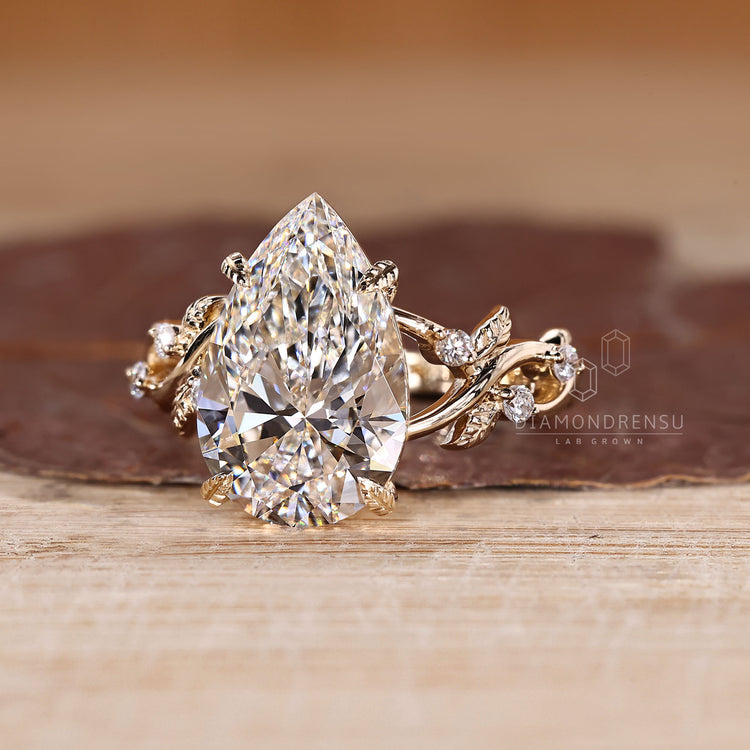 Lab grown pear diamond ring with four leaf prongs.