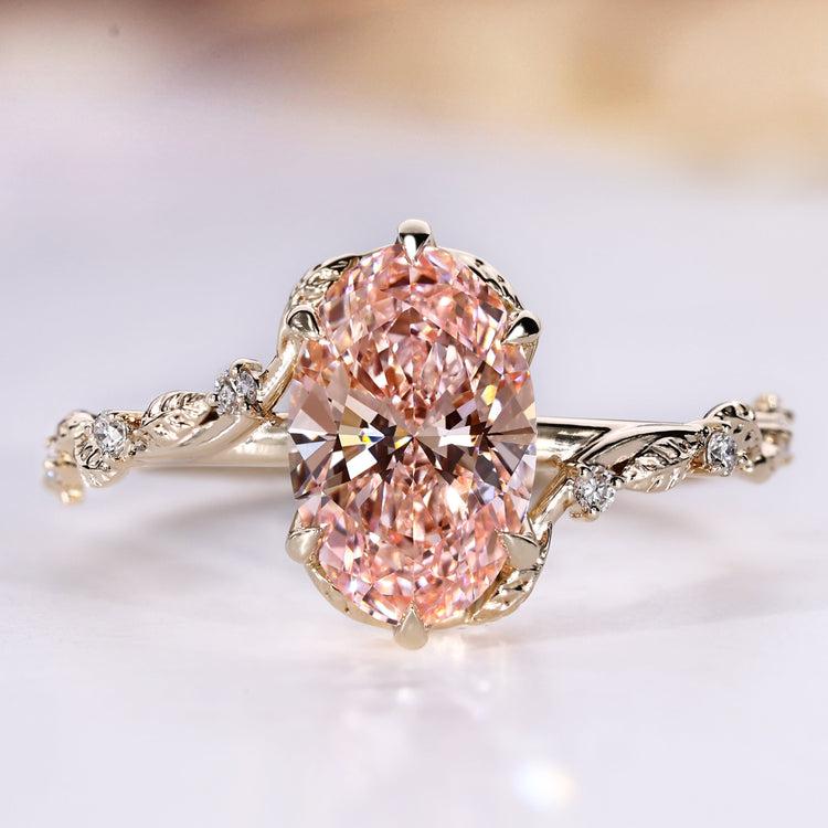Oval cut ring with pink centre diamond and round side stones.
