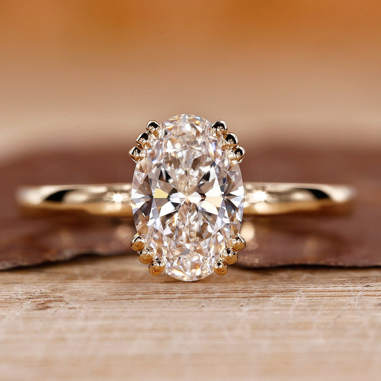 Oval cut lab grown diamond ring with triple prong setting.