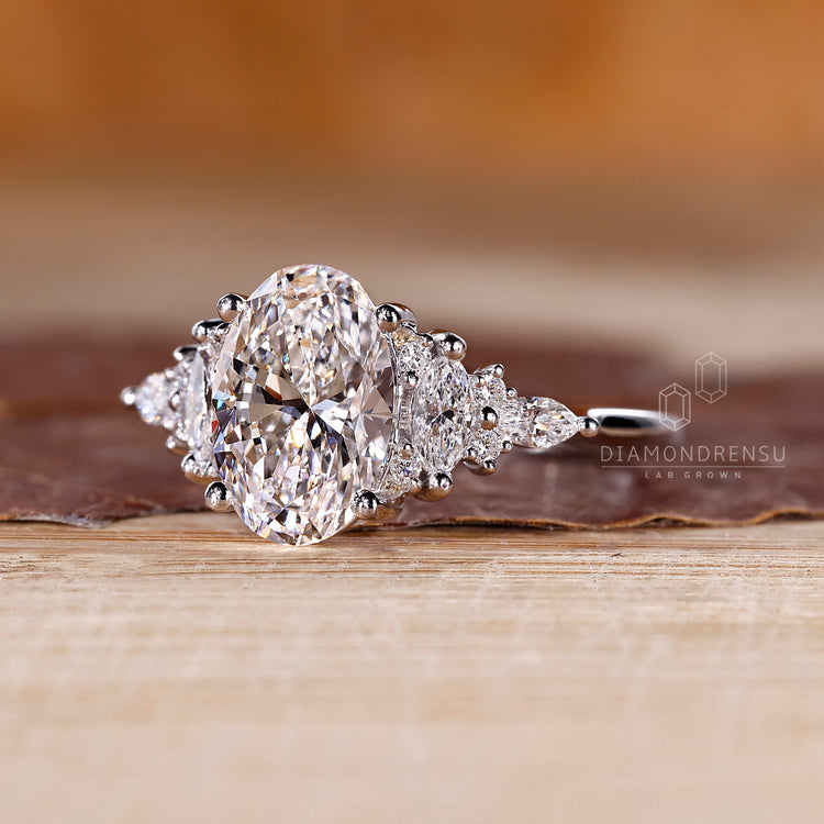 Handmade oval diamond ring with marquise and round accents.