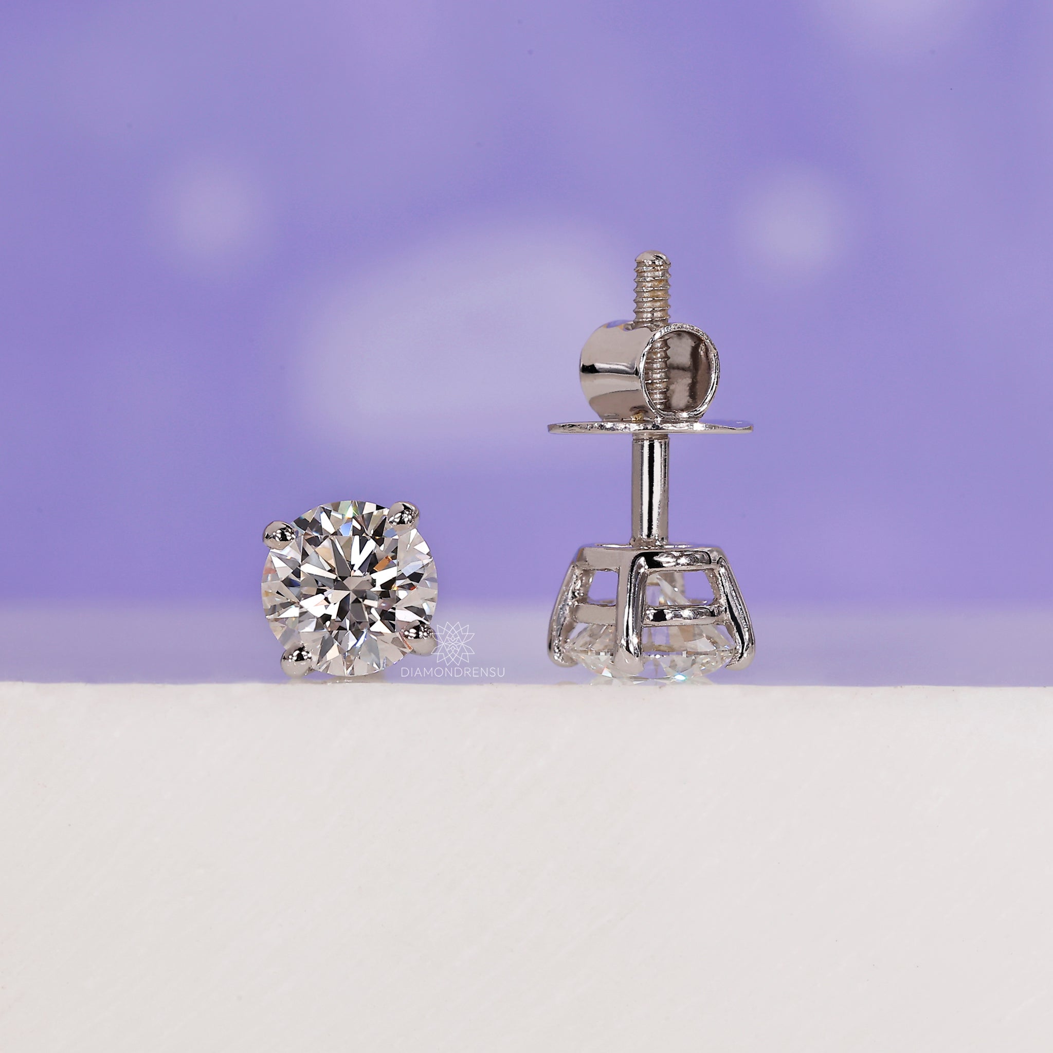 Four prong diamond stud earrings.