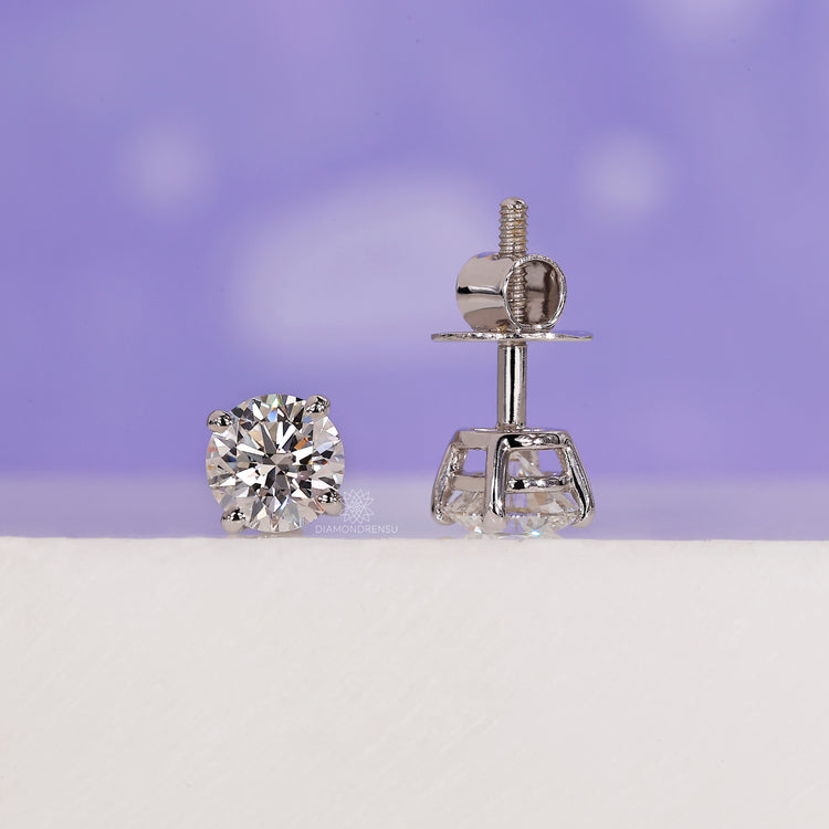 Four prong diamond stud earrings.
