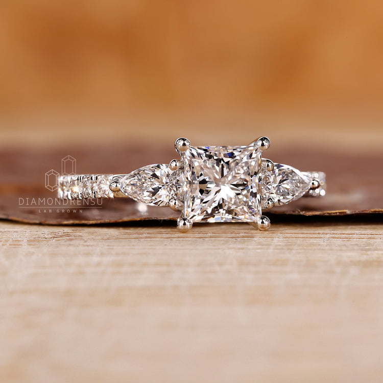 Princess cut center with pear and round diamond side stones
