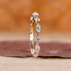 Marquise and round wedding band crafted in yellow gold with shared prong setting.