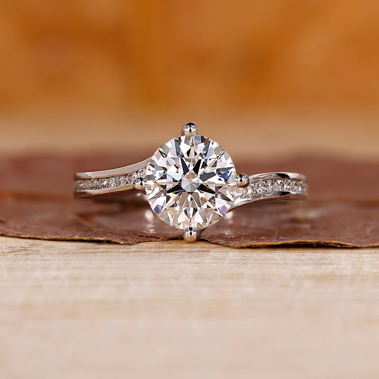 Bypass diamond ring with round cut diamond center stone.
