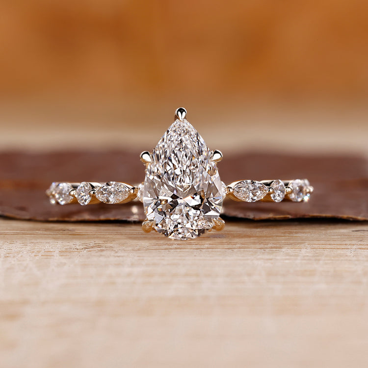 Pear engagement ring with hidden halo design.