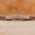 Curved diamond wedding band with round stones and milgrain detailing. Curved diamond wedding band with round stones and milgrain detailing.