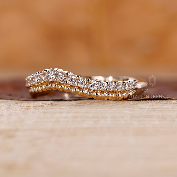 Yellow gold wedding band crafted with a curved diamond layout.