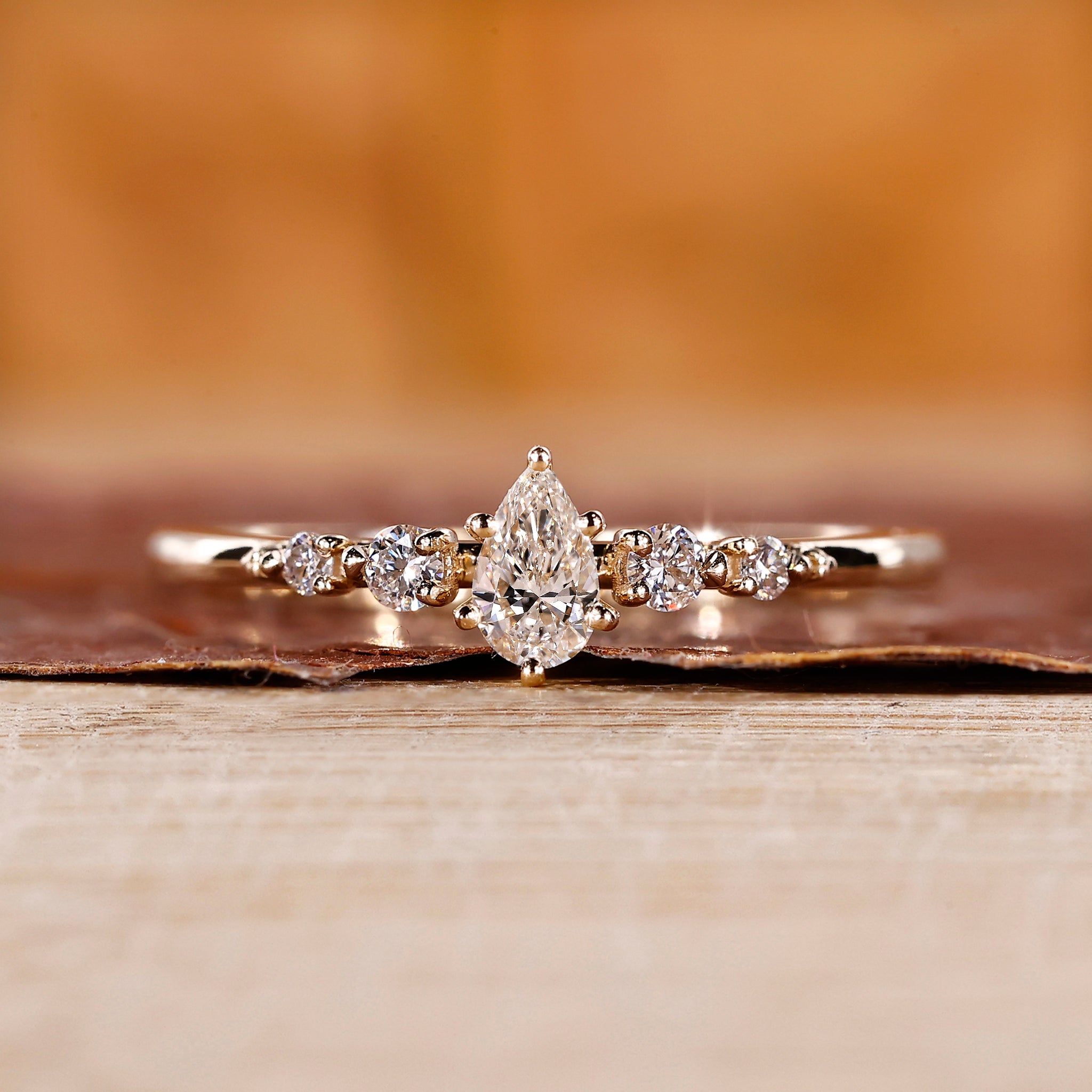 Pear shape diamond ring with round side stones