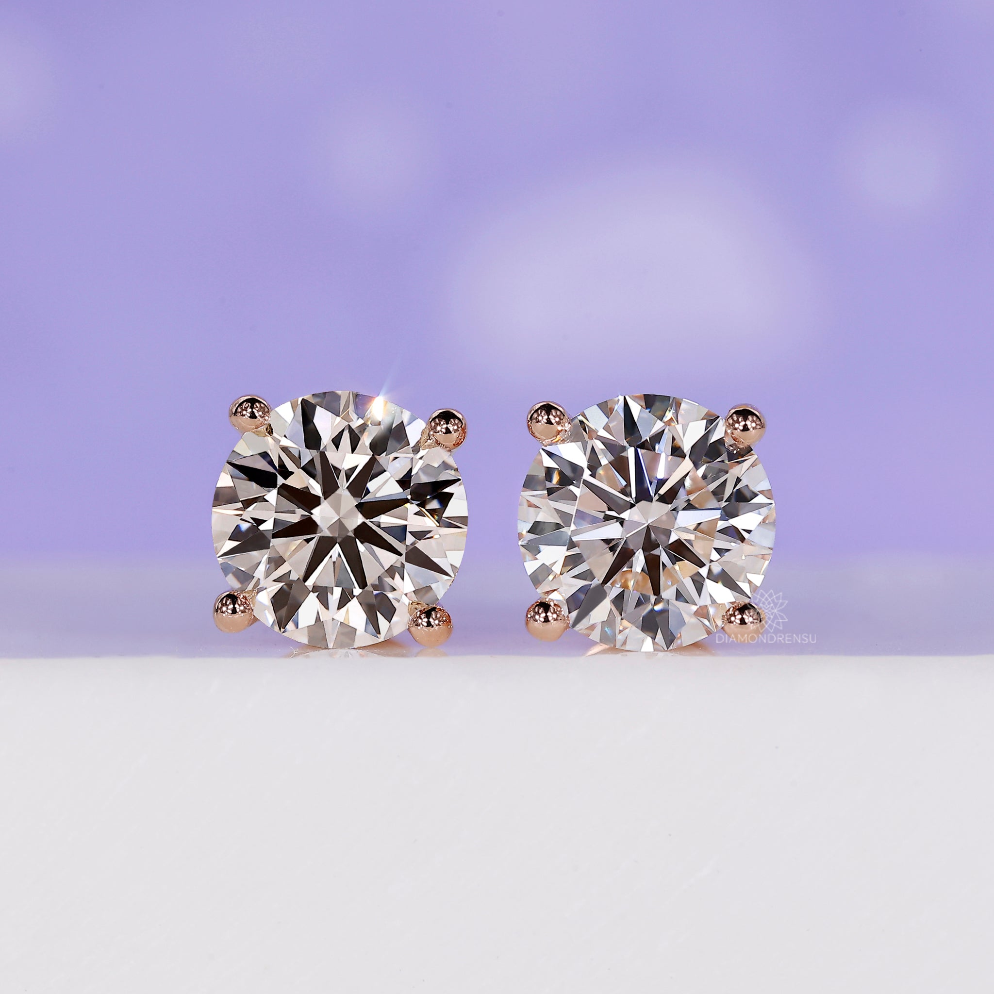 Round stud diamond earrings in rose gold.