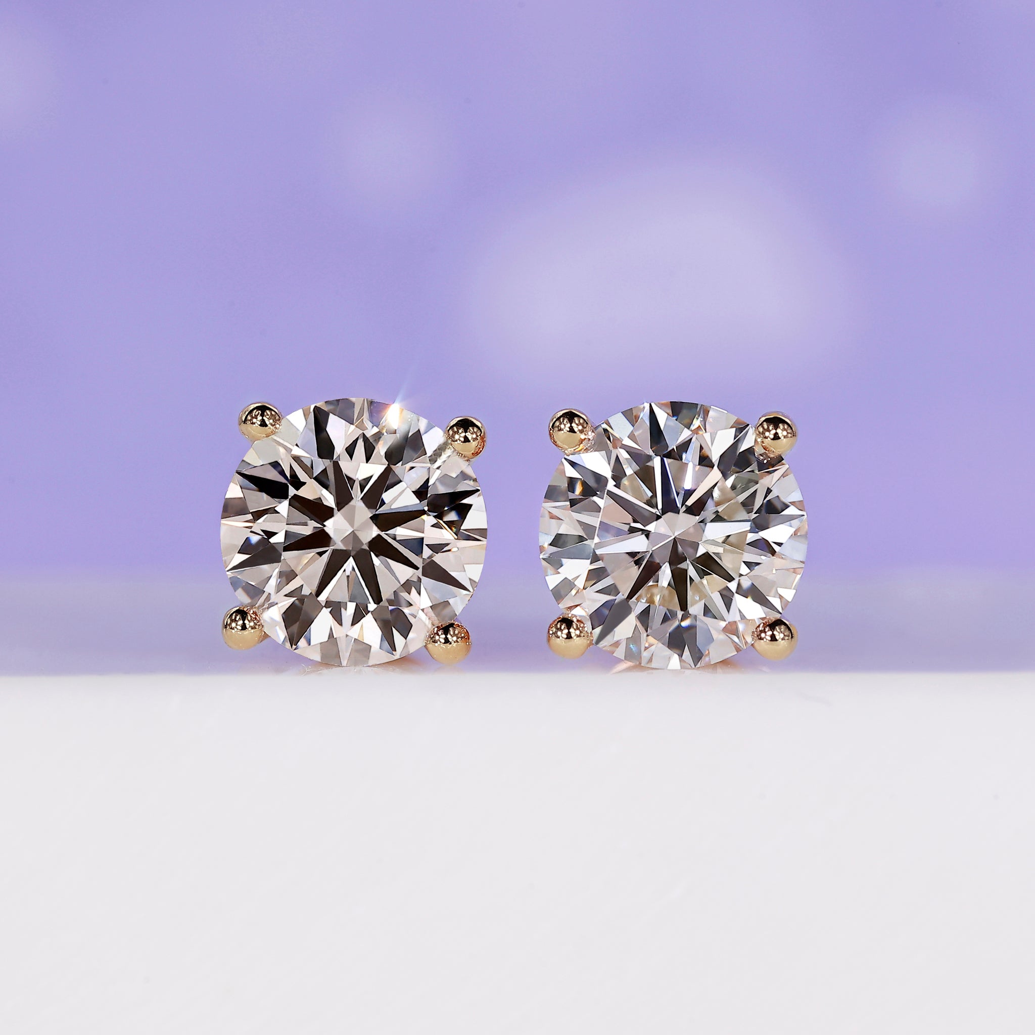 4 carat diamond stud earrings in yellow gold.