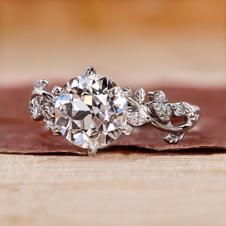 Old European cut engagement ring with marquise side stones in white gold.