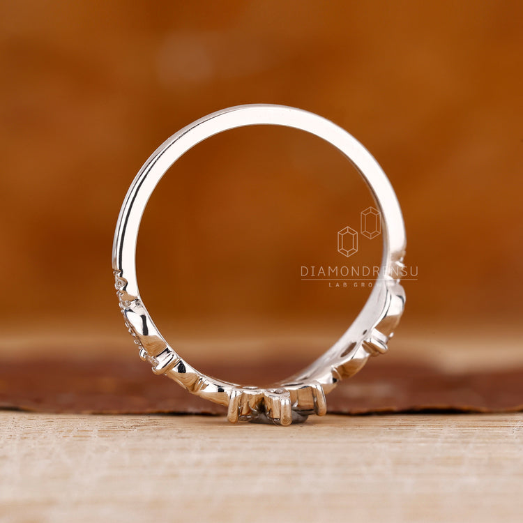 Prong set wedding band in a nature inspired design.