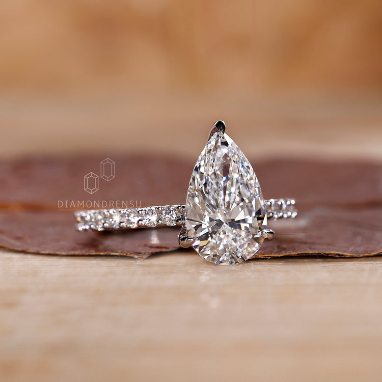 Pear and round diamond in pave diamond band setting.