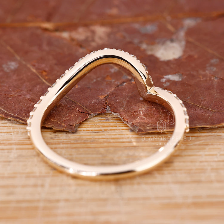 Custom diamond band with ocean wave detail in yellow gold.