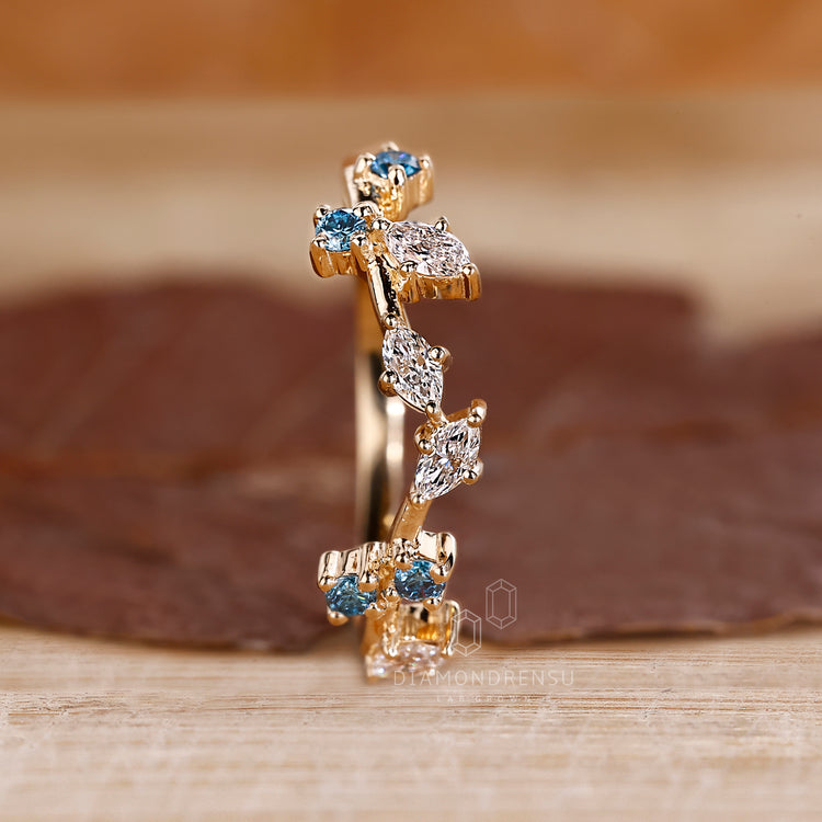 Prong setting band with blue and white diamonds.