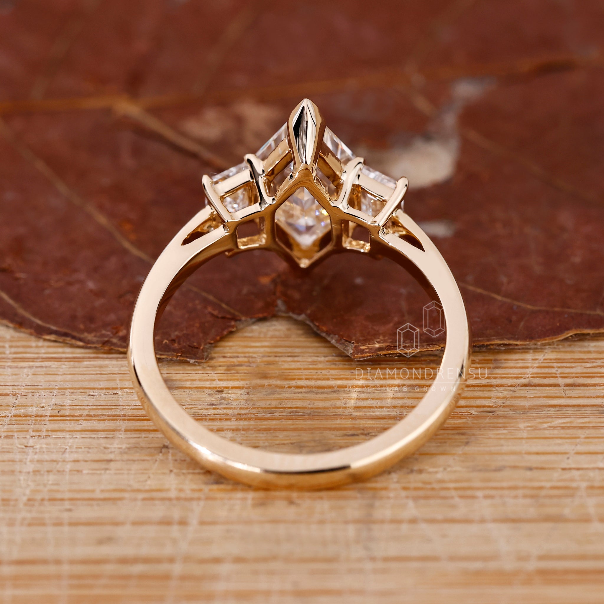 Three stone ring includes one center and two side diamonds.