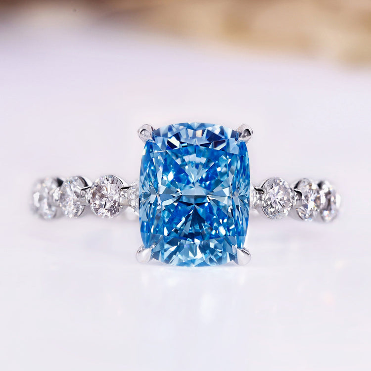 Cushion cut blue lab grown diamond ring with pave band.