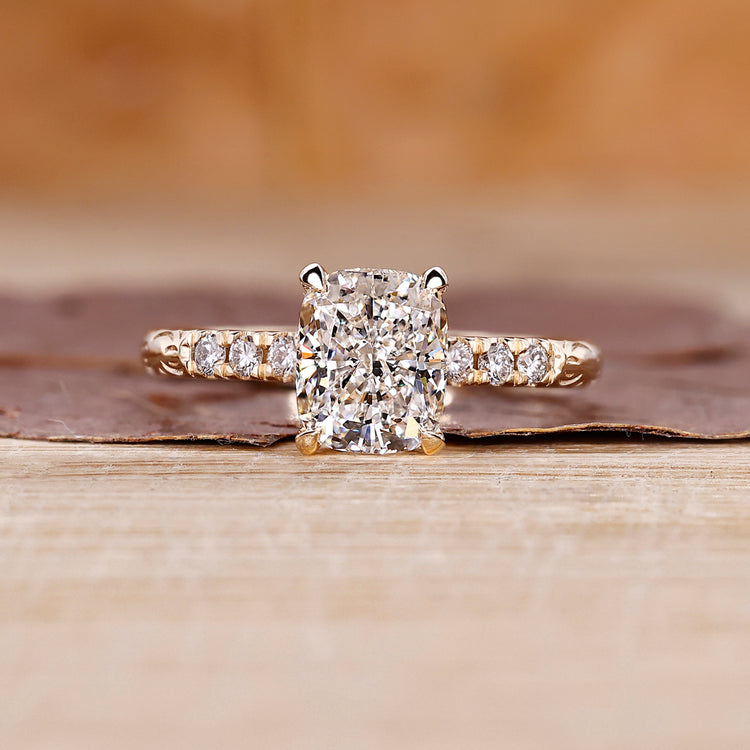 Cushion cut engagement ring includes cushion shape diamond.