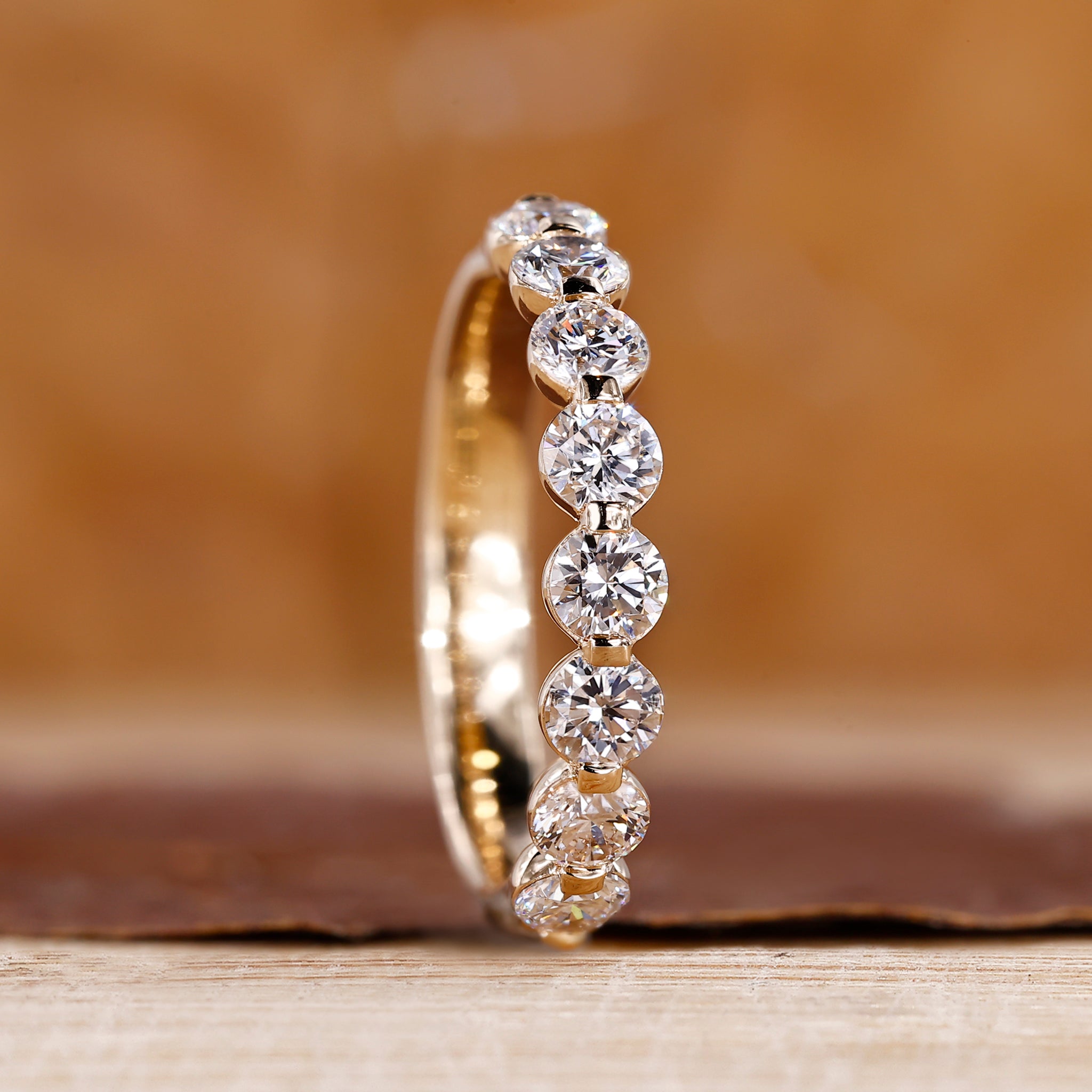 Shared prong diamond band crafted in yellow gold with a sleek design.