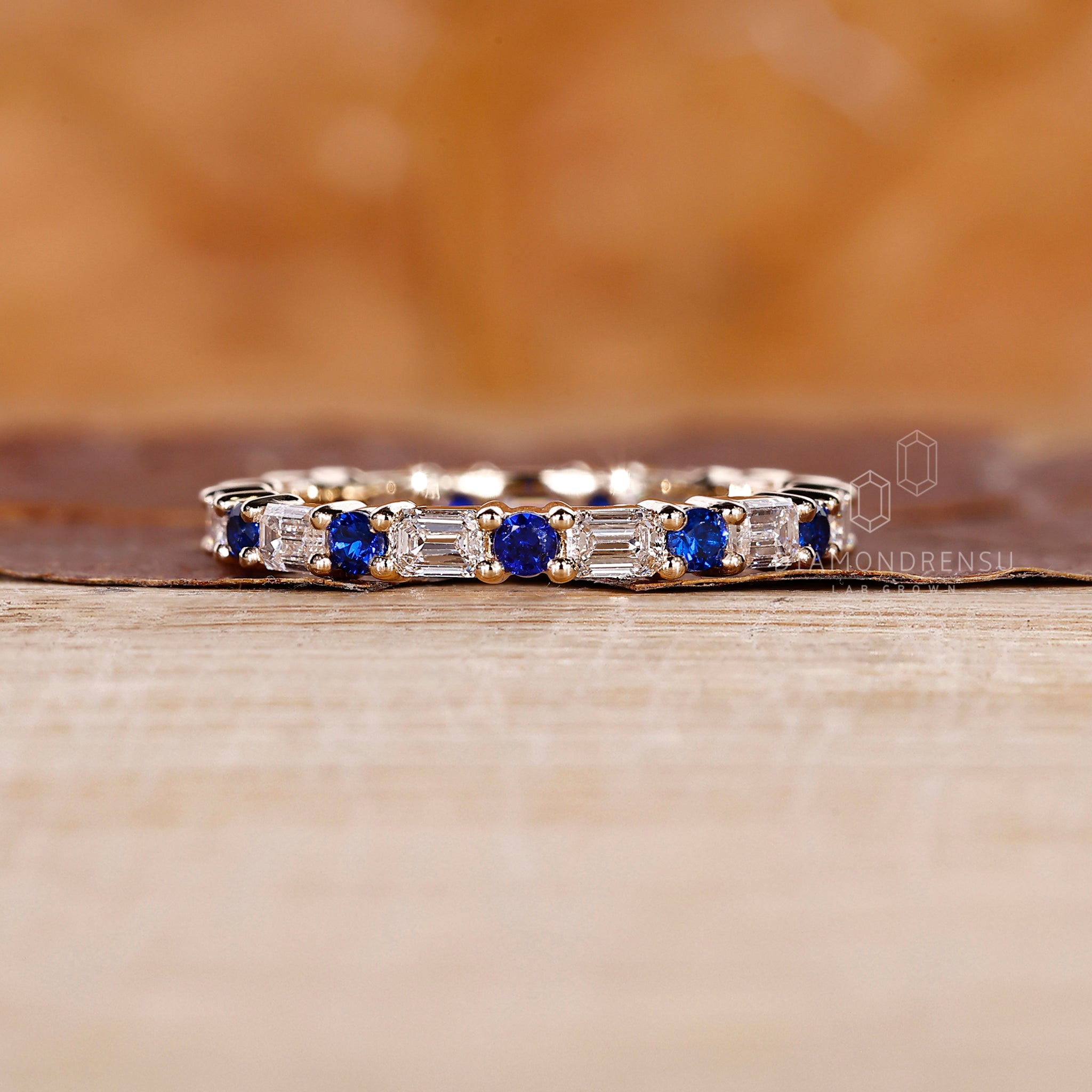 Eternity wedding band with alternating sapphires and emerald cut diamonds.